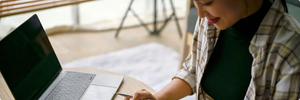 Close-up image of a woman calculating taxes and expenses in a living room.